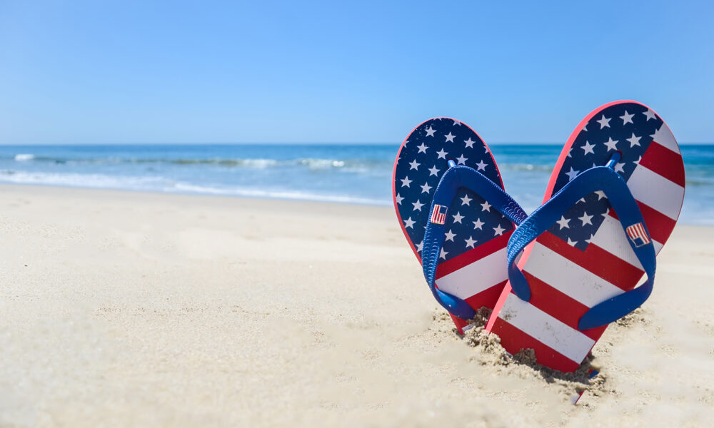 sandals-making-heart-shape-in-the-sand-on-the-beach