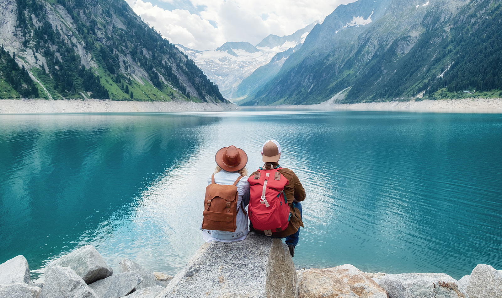 couple-traveling-together-sittin-in-front-of-mountains-and-sea