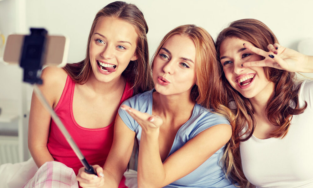 three-friends-taking-a-selfie-with-a-selfie-stick