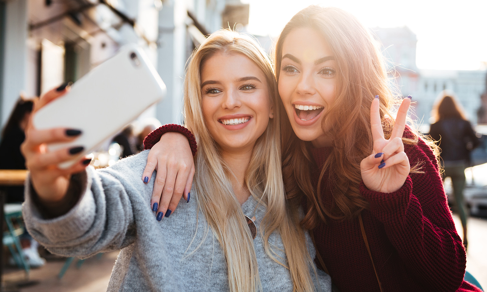 two-friends-taking-a-selife-holding-up-peace-sign 