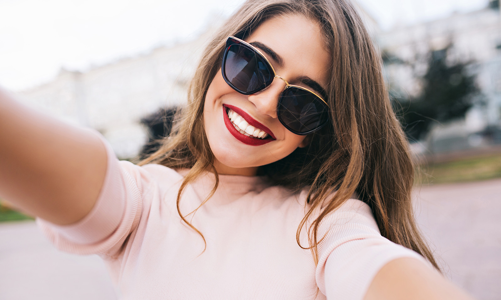 woman-in-sunglasses-with-red-lips-taking-selfie