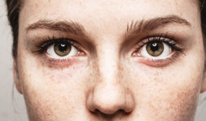 close-up-of-womans-face-with-freckles-eyebrows-eyes