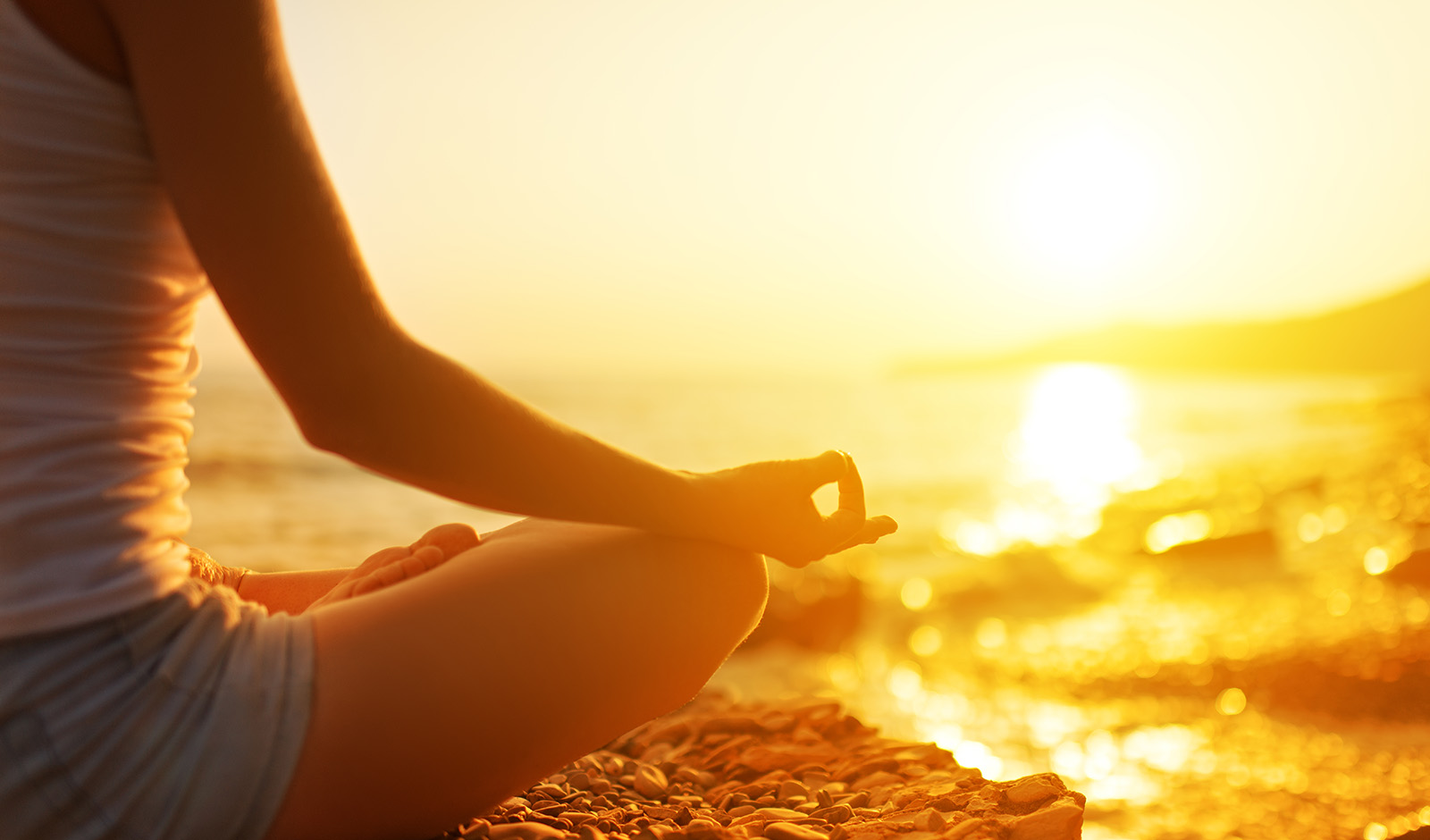 woman-sitting-on-beach-meditating