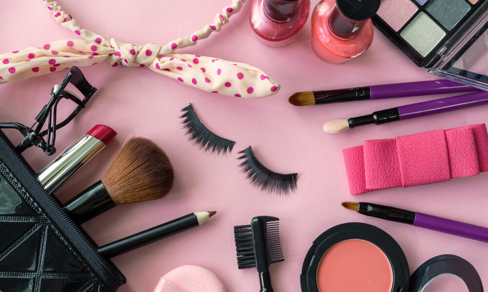 makeup-kit-makeup-items-laid-around-a-pink-background