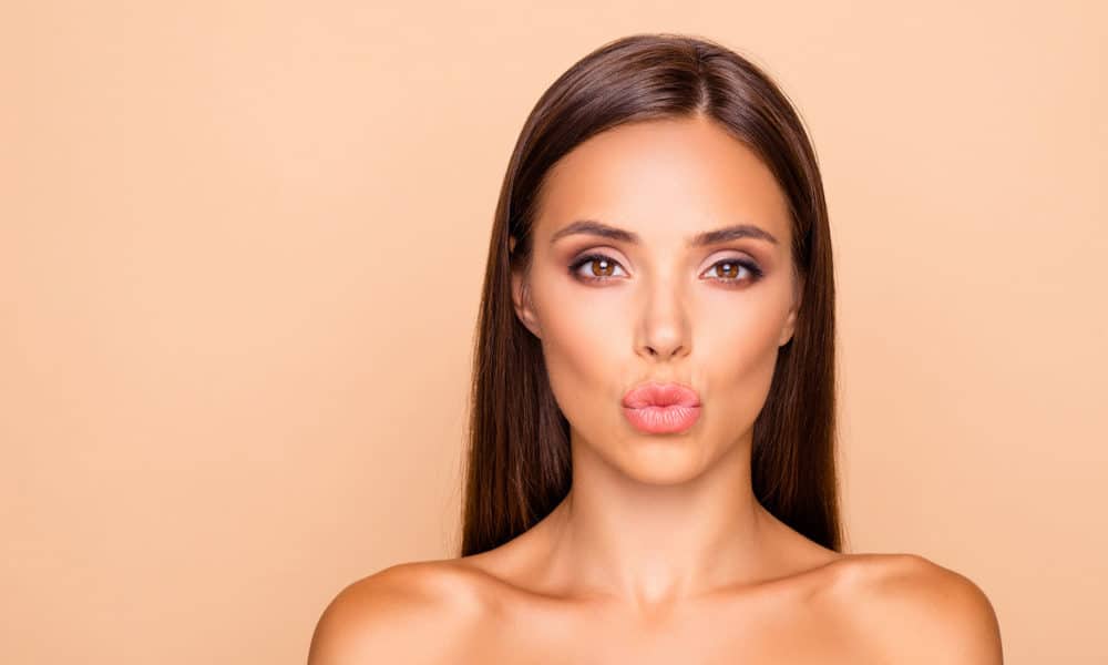 Adorable charming brunette hair lady with her naked shoulders she send kiss look at camera isolated on pastel beige background with copy space for text