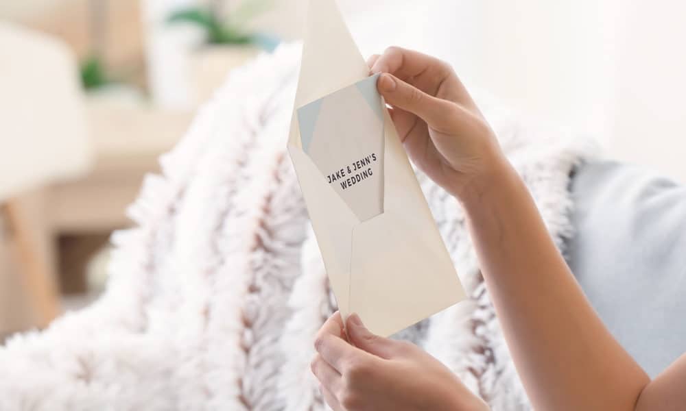 Young woman with wedding invitation at home