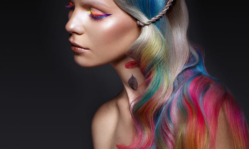 Beautiful girl with multi-colored hair and creative make-up and hairstyle. Beauty face. Photo taken in the studio