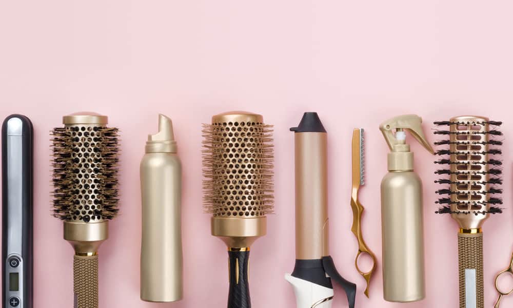 Professional hair dresser tools on pink background with copy space