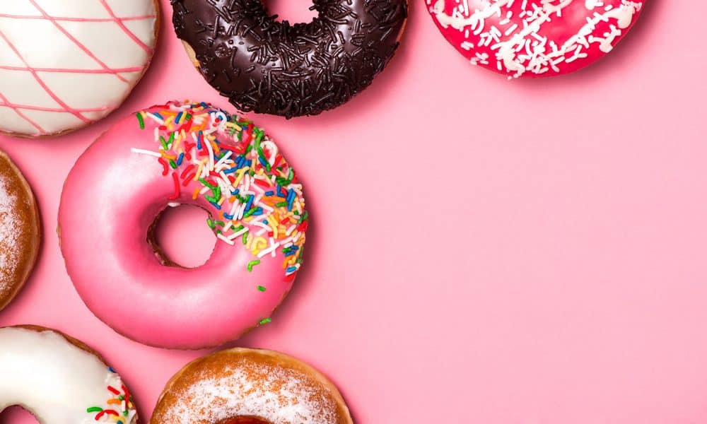 Donuts with icing on pastel pink background. Sweet donuts.