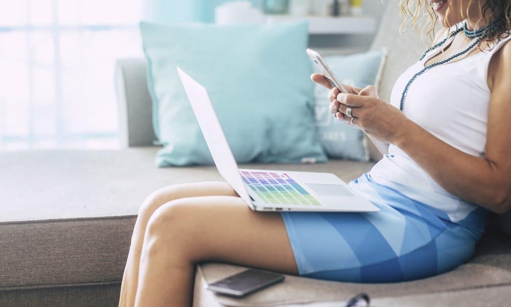 Lady at work at home sit down on the sofa using new modern techn