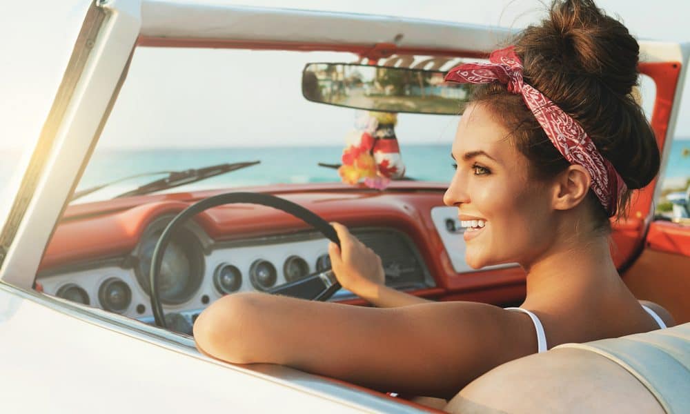 Beautiful and happy woman inside a retro car