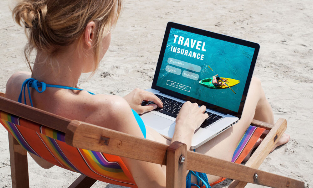 woman-on-beach-travel-insurance-online-shopping